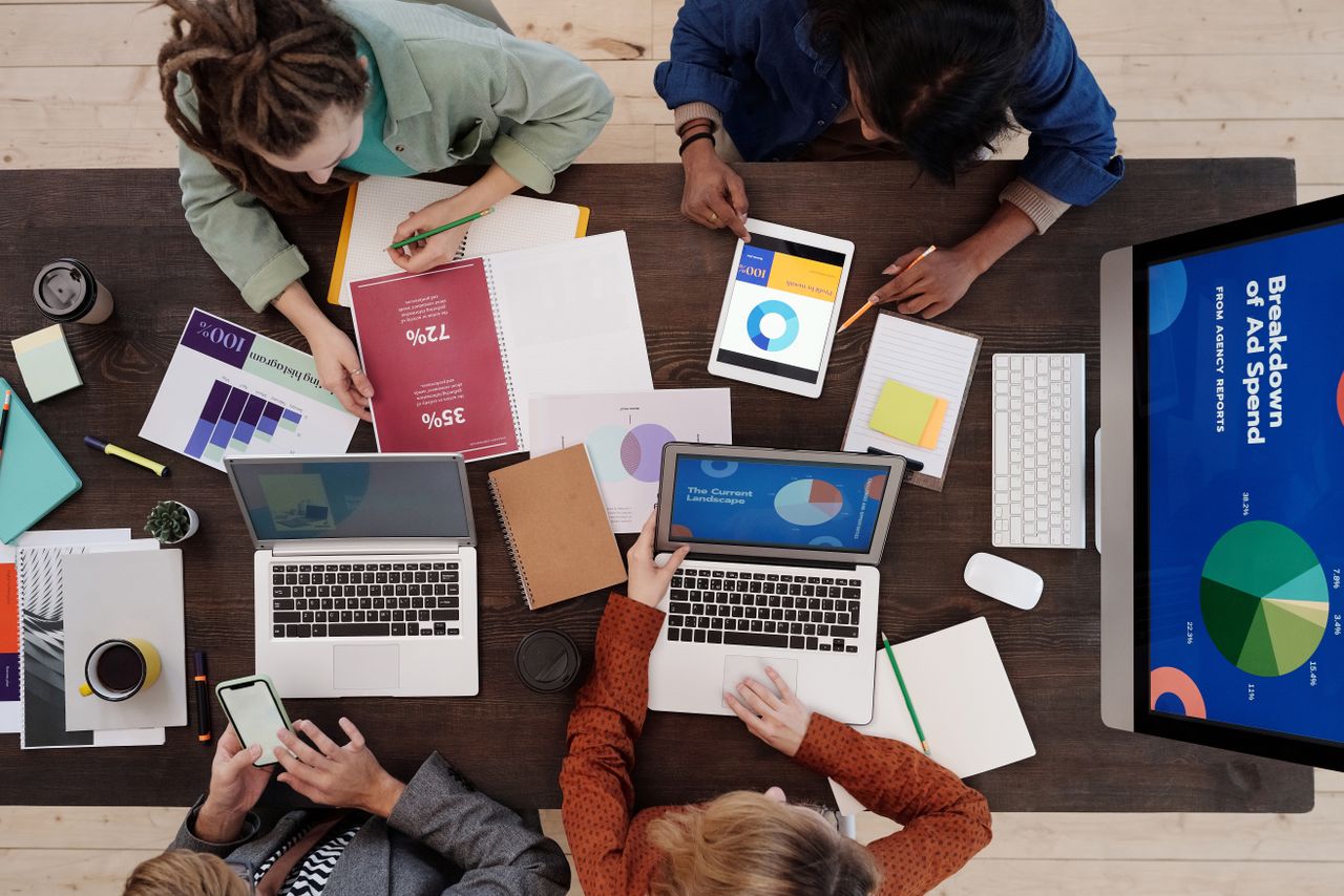 Mastering the First Impression: Your intriguing post title goes here A diverse team collaborating on digital marketing strategies at a desk, using laptops and tablets.